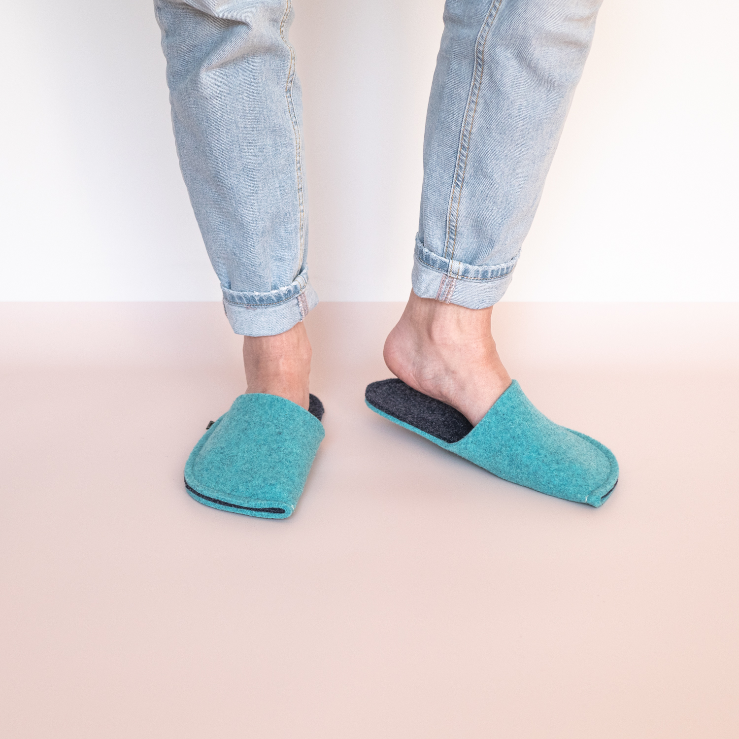 A woman wearing turquoise blue and navy blue slippers