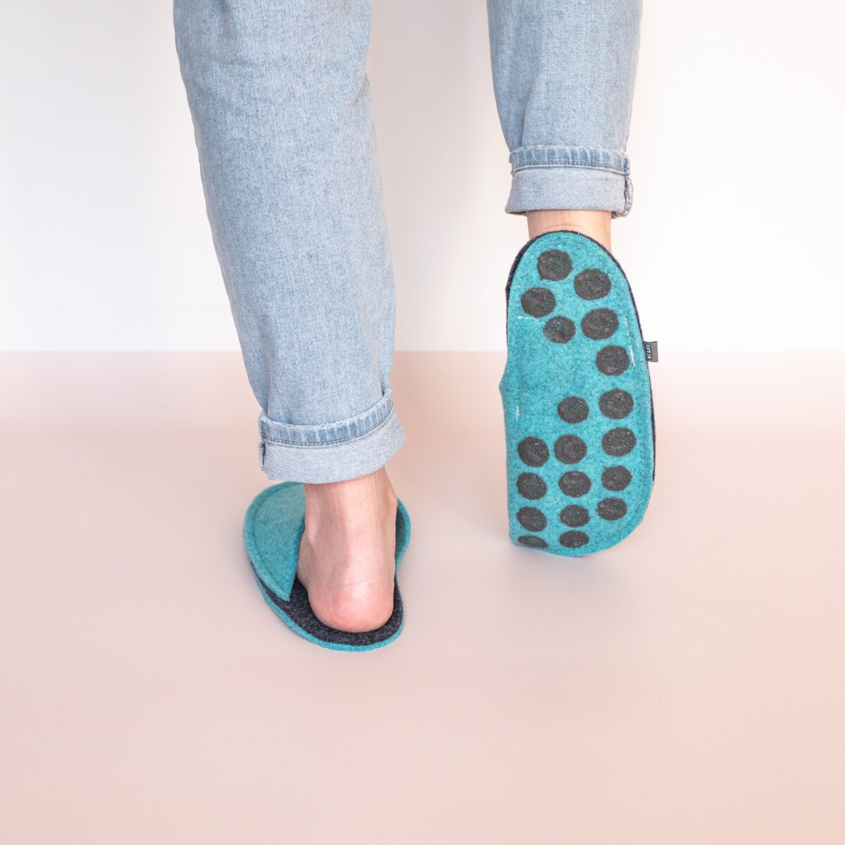 A woman wearing turquoise blue and navy blue slippers