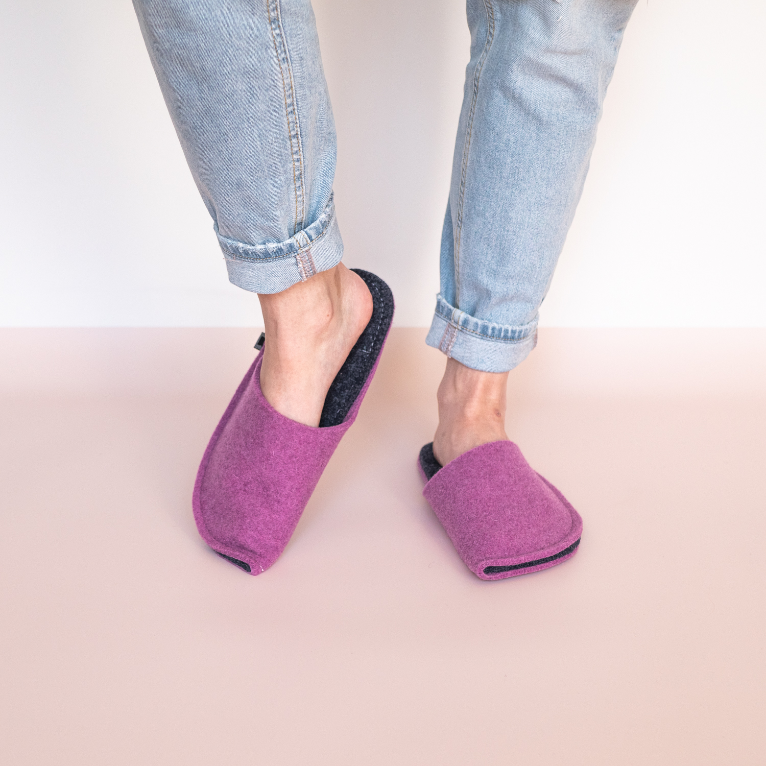 A woman wearing orchid purple and navy blue slippers