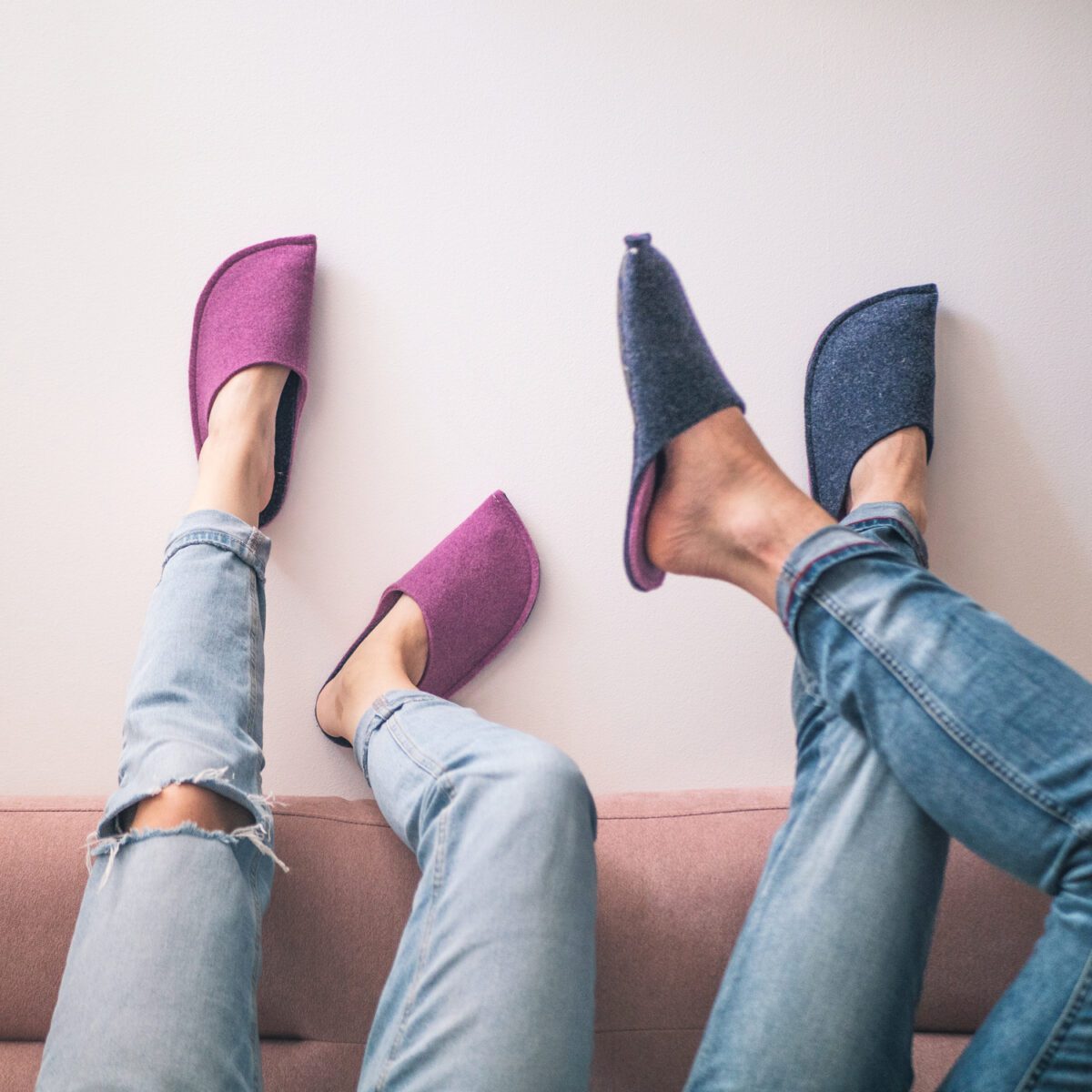 A couple wearing orchid purple and navy blue slippers