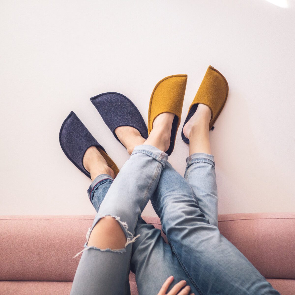 A couple wearing curcuma yellow and navy blue slippers