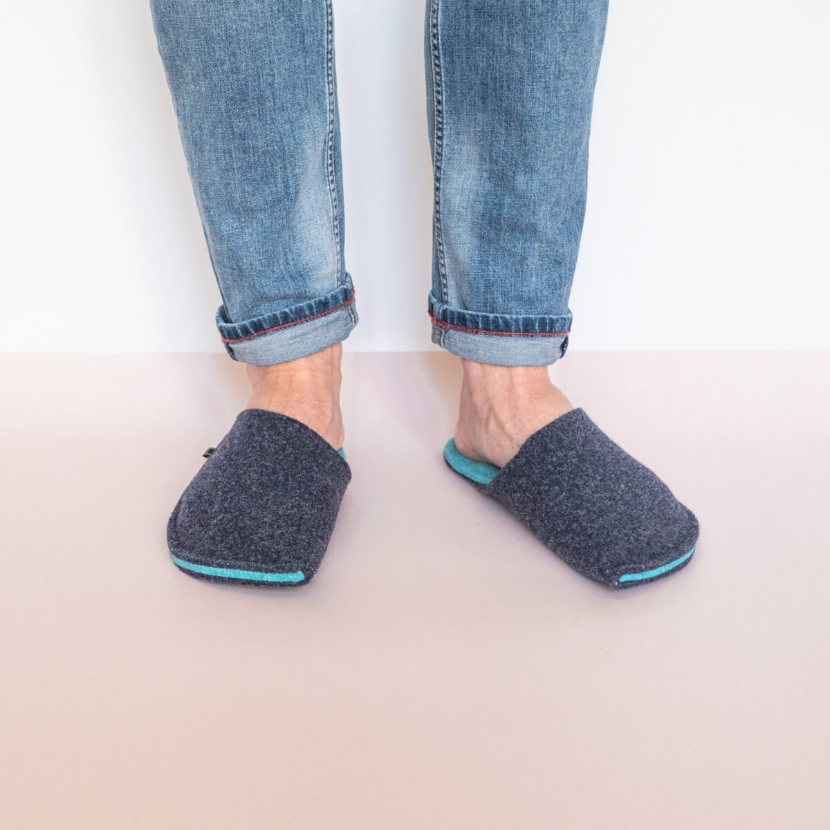 A man wearing navy blue and turquoise blue slippers