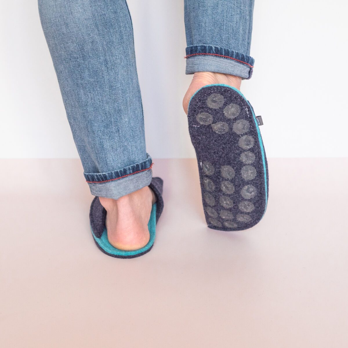 A man wearing navy blue and turquoise blue slippers