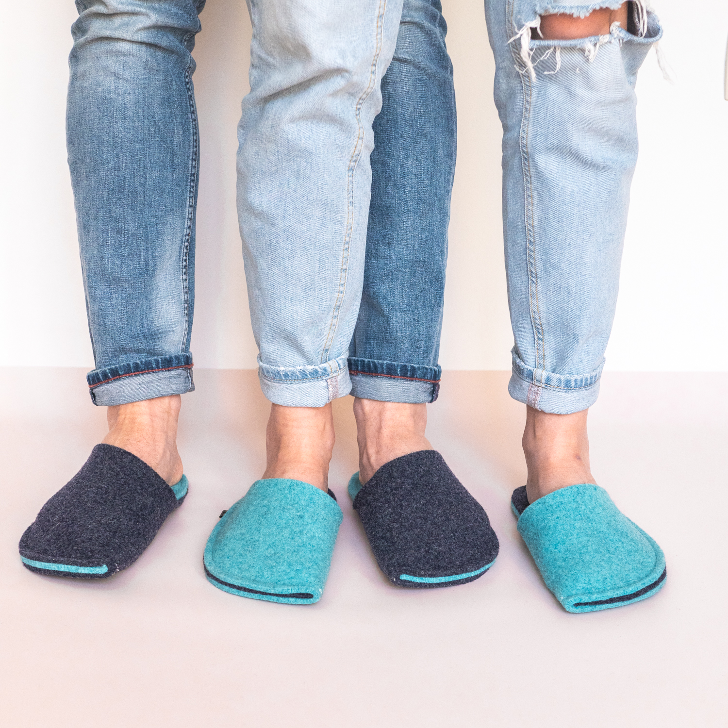 A couple wearing turquoise blue and navy blue slippers