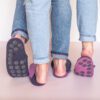 A couple wearing orchid purple and navy blue slippers