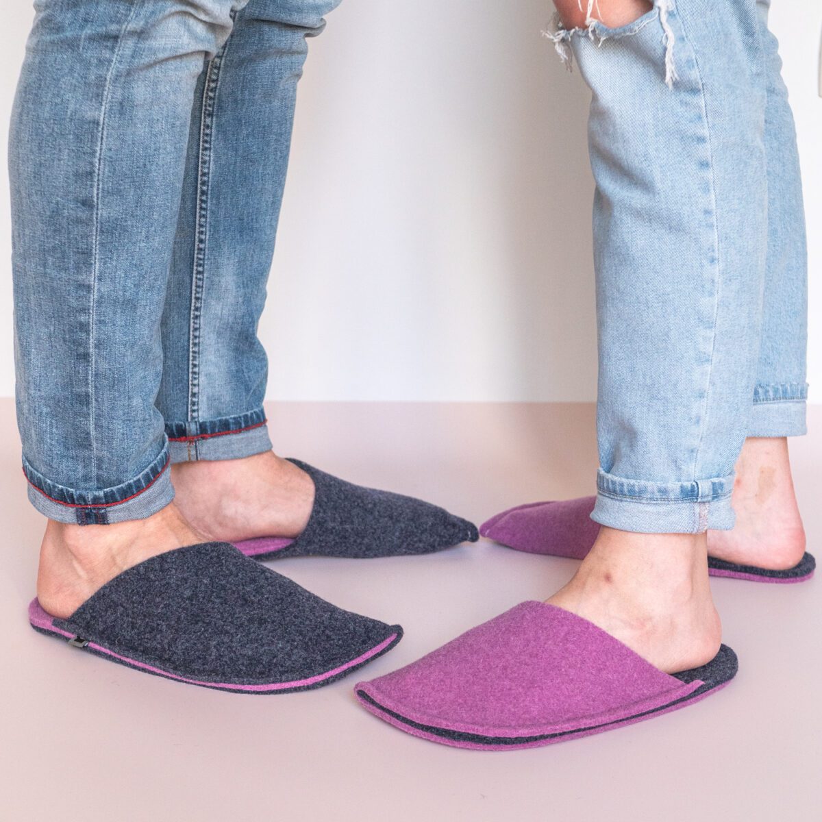 A couple wearing orchid purple and navy blue slippers