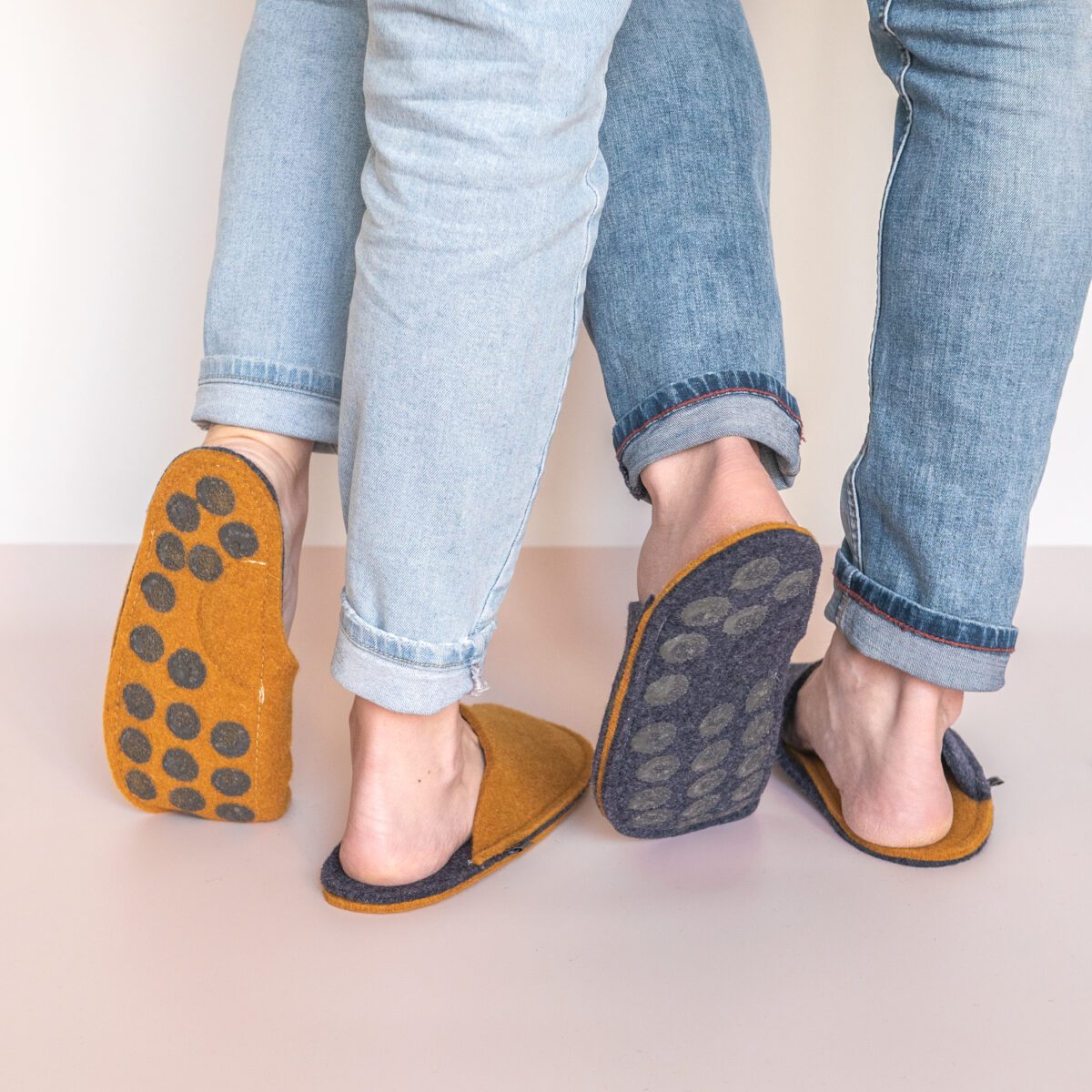 A couple wearing curcuma yellow and navy blue slippers