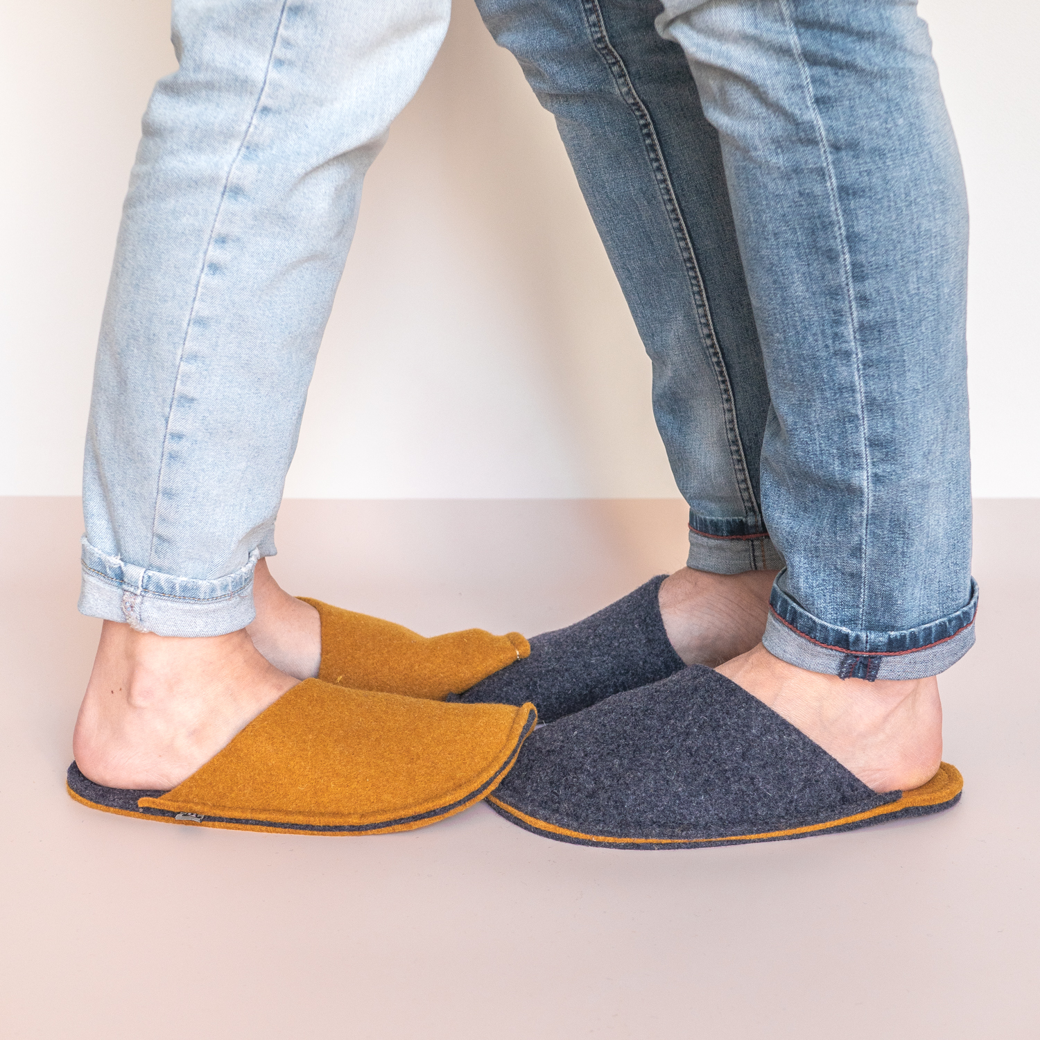 A couple wearing curcuma yellow and navy blue slippers