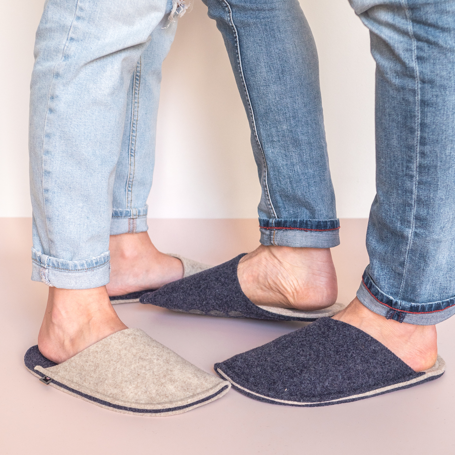 A couple wearing cream white and navy blue slippers