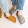 A couple wearing house slippers made of grayish brown and curcuma yellow wool felt