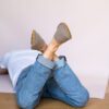 A man wearing house slippers made of curcuma yellow and grayish brown wool felt