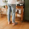 A man wearing house slippers made of cream white and grayish brown wool felt